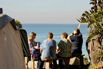 Campers sharing a picnic table overlooking the sea at Yellow Sands